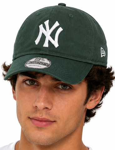 models wearing a dark green New York Yankees baseball cap with a white embroidered NY logo and a white New Era 9FIFTY sticker on the visor