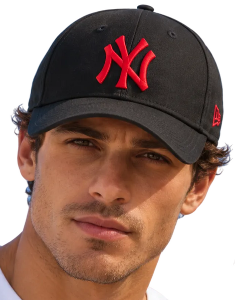 Two models wearing black New York Yankees baseball caps with red embroidered logos, photographed outdoors against a clear blue sky.