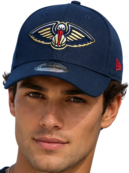 Two models wearing matching navy blue New Orleans鹗队 baseball caps with gold and red embroidered logos, set against a clear blue sky.