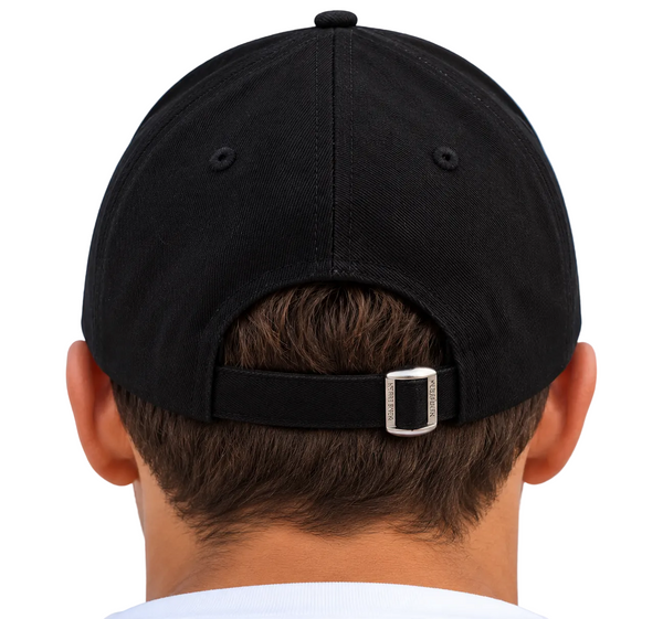 Rear view of a man wearing a black baseball cap with an adjustable strap and silver metal buckle, set against a light blue sky background.