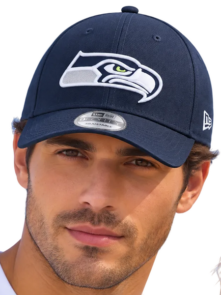 Two models wearing navy blue Seattle Seahawks baseball caps with the white and green team logo, photographed against a clear light blue sky.